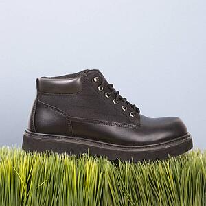 Studio shot of black leather shoe resting on grass