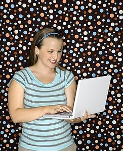 Woman typing on laptop and smiling