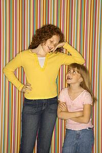 Caucasian female child leaning on smaller female child.