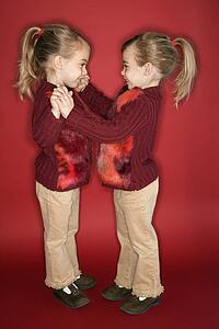 Female twins standing in dance stance