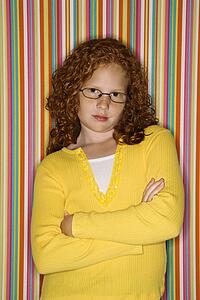 Child with arms crossed wearing eyeglasses