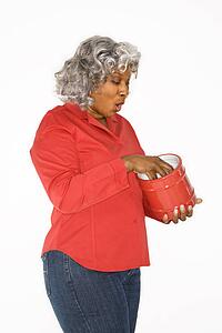 Mature adult African American female with hand in jar.