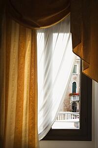 Window with drapes in Venice, Italy.