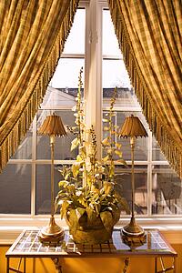 Window with curtains pulled back and decorative table with lamps