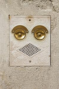 Close-up of ringer and speaker on side of building that look like a face in Venice, Italy