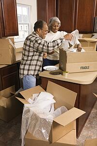 Couple packing moving boxes in kitchen
