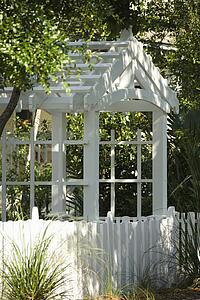 Garden arbor with white picket fence.
