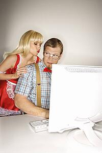 Man dressed like nerd at computer looking over shoulder at woman