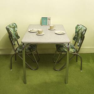 Formica and chrome dinette set with green vinyl chairs.