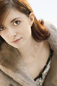 Head and shoulder portrait of attractive young redhead Caucasian woman.