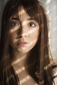 Portrait of pretty Caucasian young woman with sunlight through window.