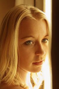 Caucasian young adult blond woman looking to side.