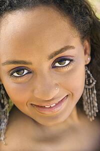 Close-up of young-adult Black woman making eye contact.