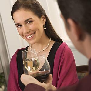 Mid adult Caucasian couple smiling and toasting wine glasses.