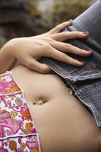 Close up of young female laying down with hand on hip and bare midriff