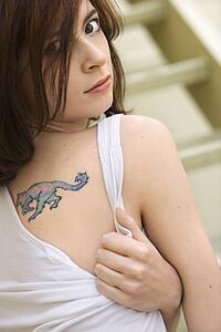 Portrait of attractive young redhead Caucasian woman with tattoo on shoulder.