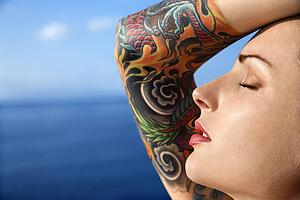 Close up portrait of tattooed woman with Pacific Ocean in background 