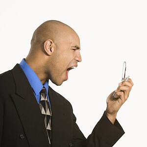 Profile of angry businessman shouting into phone
