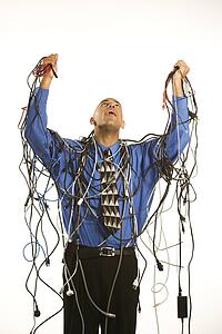Businessman holding tangled cords