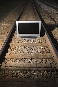 Flat panel television set on railroad tracks at night