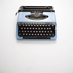 Blue vintage typewriter on white background
