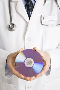 Close up of physician holding compact disc.