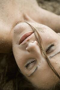 Head shot of pretty young adult woman with eyes closed