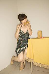 Young adult woman sitting at table eating