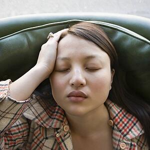 Woman sitting in green chair with eyes closed