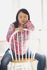 Woman sitting on chair at table in kitchen