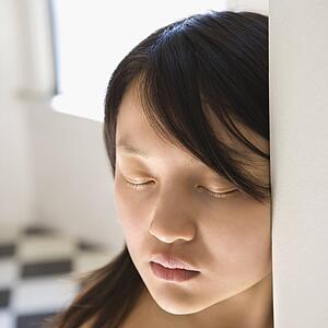 Portrait of bare pretty young Asian woman with eyes closed.