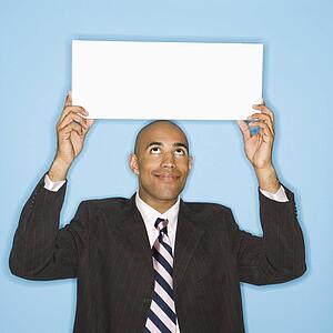 Man holding blank sign against blue background