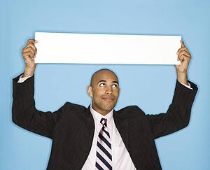 Man holding blank sign against blue background