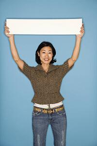 Woman holding blank sign on blue background