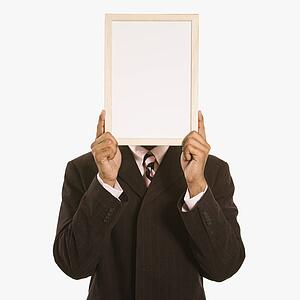 Man holding blank sign over his face standing against white background