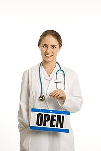 Portrait of doctor holding up open sign