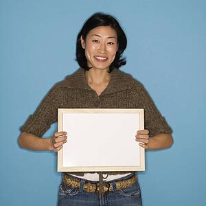 Woman holding blank sign on blue background