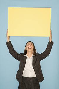 Businesswoman smiling holding blank sign