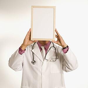 Male doctor holding blank sign over face