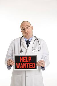 Physician holding help wanted sign