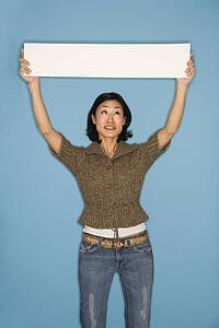 Woman holding blank sign on blue background