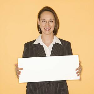 Businesswoman smiling holding blank sign
