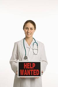 Doctor holding up help wanted sign
