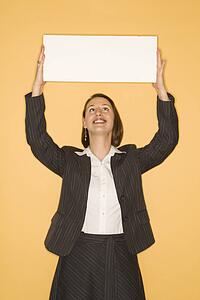 Businesswoman smiling holding blank sign