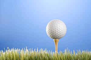 Studio shot of a golf ball on a tee in grass.