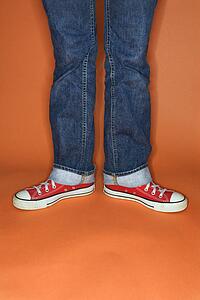 Jeans and sneakers with feet turned outward