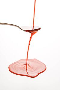 red cough syrup overflowing spoon 