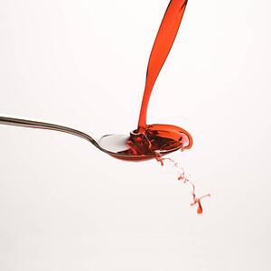 red cough syrup splashing out of spoon
