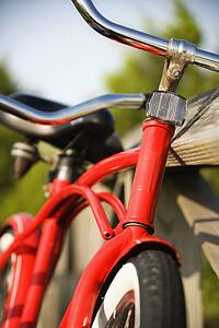 Red bike leaning against railing of boardwalk