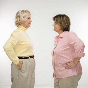 Senior woman and middle aged woman face to face arguing.